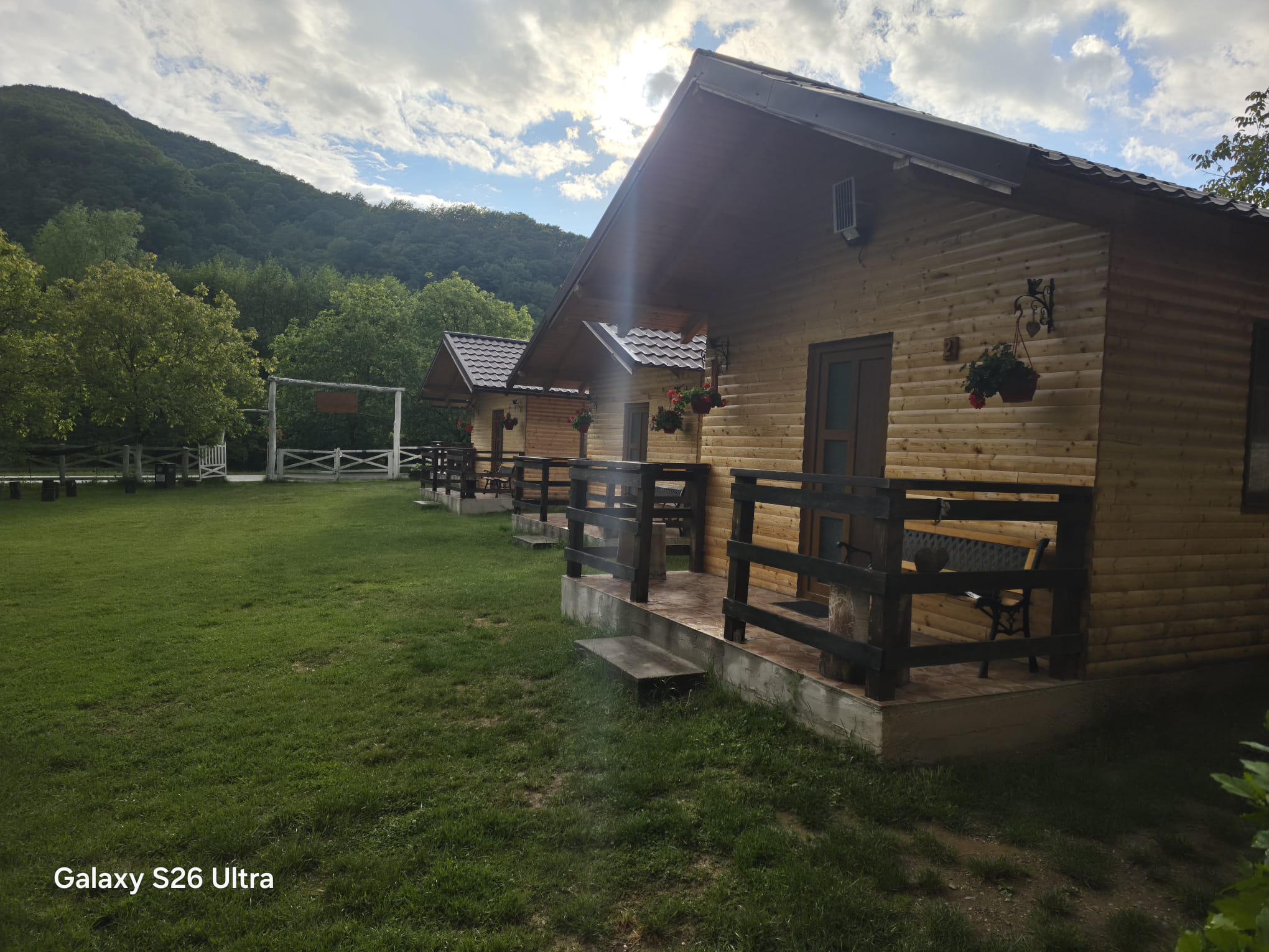 Cabană de lemn cu verandă, la apus