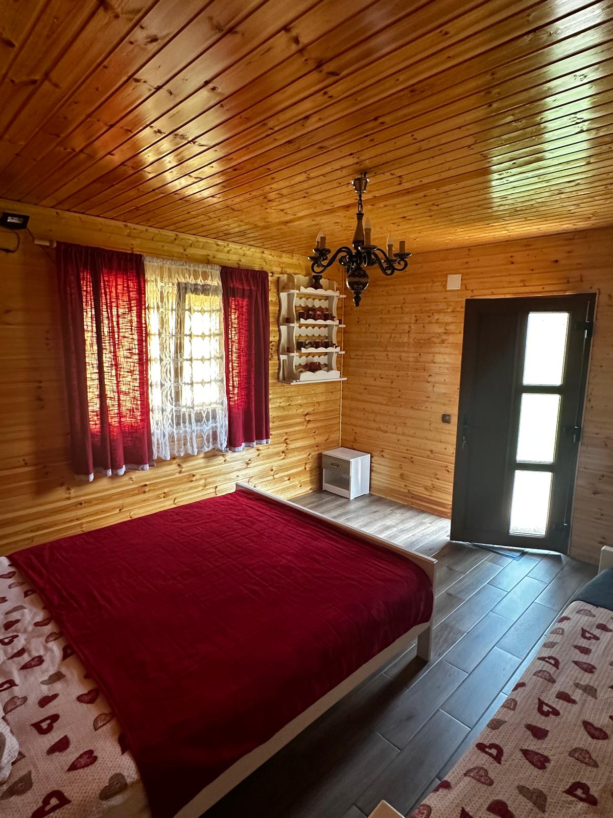 Interior de cabană cu pat dublu și lumină caldă